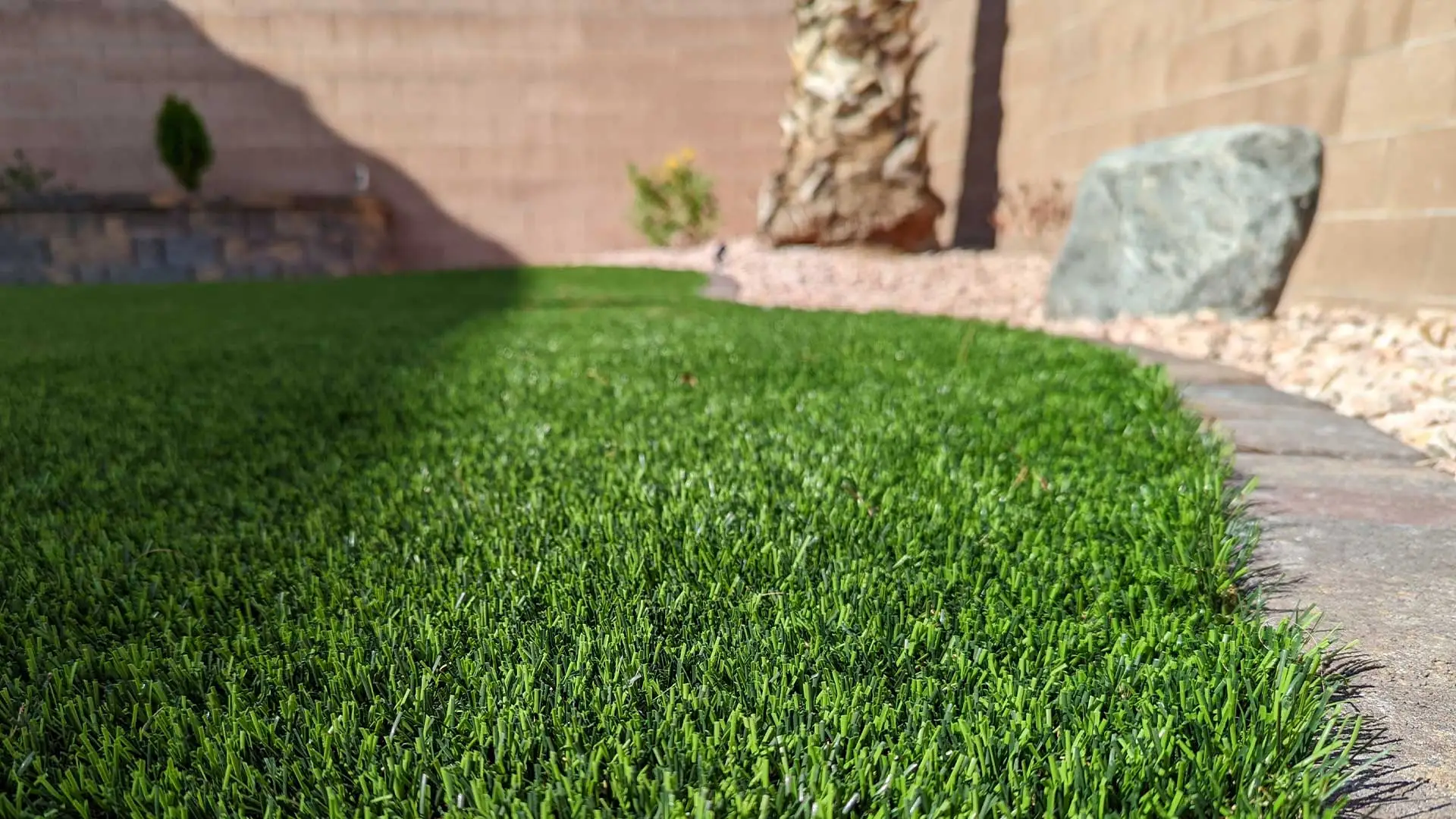 Green manicured lawn with rock border in Las Cruces, MN recently cleaned up by our team.
