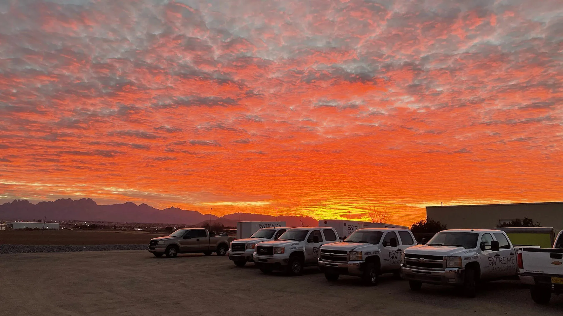 Sunset sky in the background of branded work trucks in El Paso, TX.