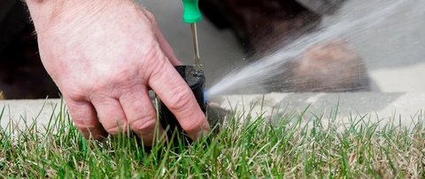 A professional repairing a sprinkler head near Mesilla, NM.