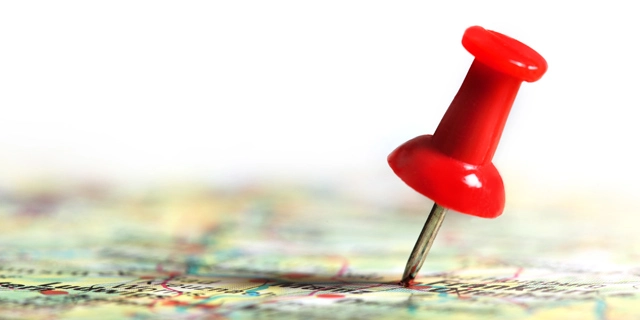 Red thumbtack over a map near New Mexico.